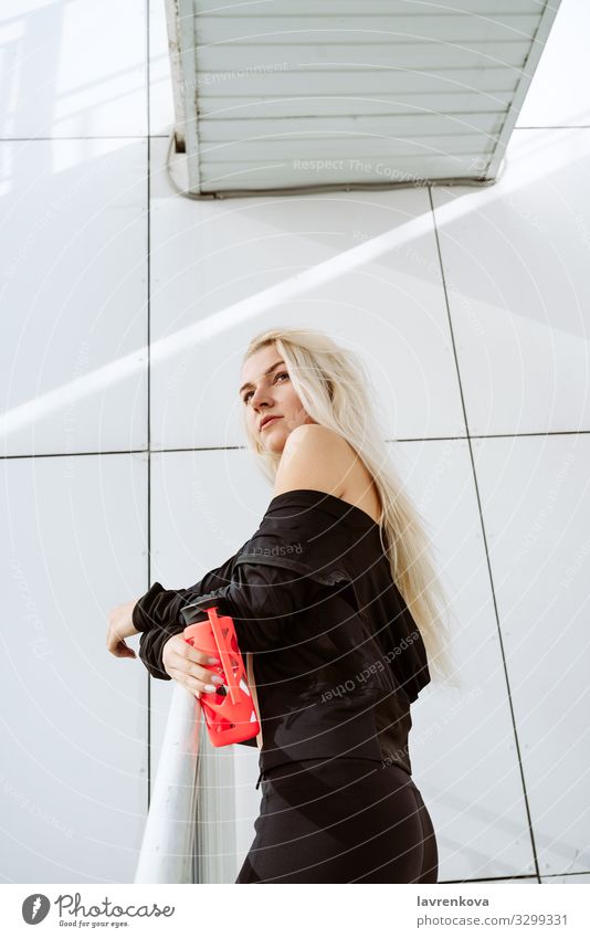 Blonde Athletin mit einer wiederverwendbaren Flasche nach der Arbeit im Freien Aktion Einsamkeit blond Kaukasier Großstadt Bekleidung Junge Frau Mädchen modern