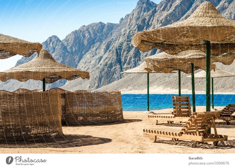 Sonnenschirme und Liegestühle am Strand in Ägypten Erholung Ferien & Urlaub & Reisen Tourismus Sommer Meer Berge u. Gebirge Sand Himmel Felsen Küste Holz heiß