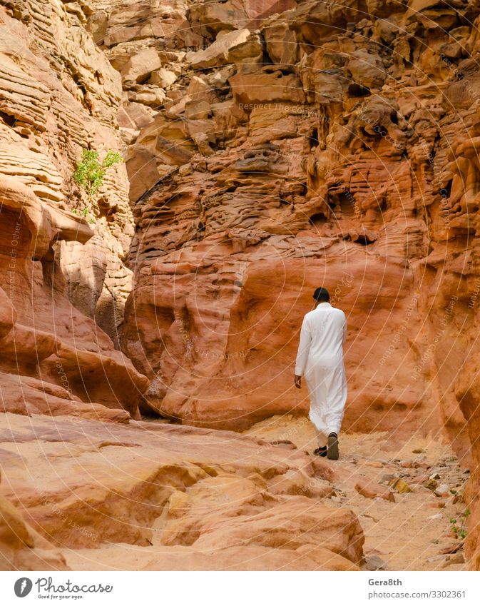 Mann in weißer arabischer Kleidung wandert in einer farbigen Schlucht in Ägypten exotisch Ferien & Urlaub & Reisen Tourismus Sommer Berge u. Gebirge Mensch