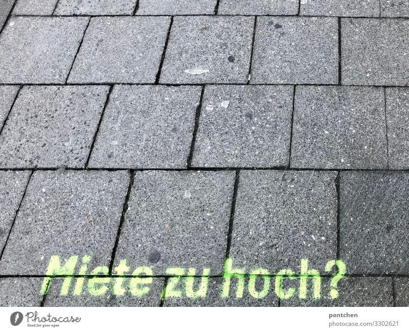 Aufdruck frage Miete zu hoch auf Pflastersteinen. Mietwucher. Immobilienbranche München Wandel & Veränderung Wege & Pfade Ziel Zukunft Graffiti mietwucher