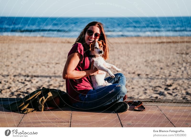 glückliche Frau und ihr süßer Liebling sitzen am Strand Hund Jack-Russell-Terrier Liebe Sonnenuntergang Zusammensein weiß Freizeit & Hobby schön Lifestyle