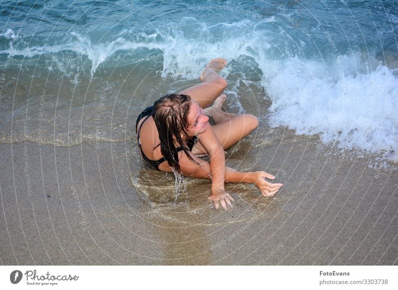Junges Mädchen wurde auf einem Sandstrand am Meer von einer Welle umgestoßen Frau Strand MEER Menschen lustig Spaß Freude toben Urlaub Wasser ausgelassen