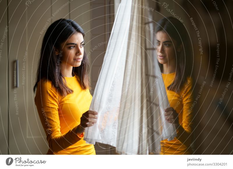 Persische Frau zu Hause beim Blick durch das Fenster Lifestyle Glück schön Haare & Frisuren Gesicht Erholung Winter Wohnung Mensch feminin Junge Frau