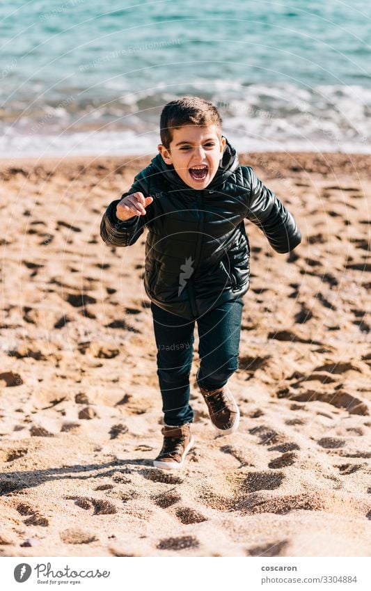 Kleines Kind rennt an einem Wintertag am Strand Lifestyle Freude Glück schön Leben Freizeit & Hobby Spielen Ferien & Urlaub & Reisen Freiheit Meer Mensch