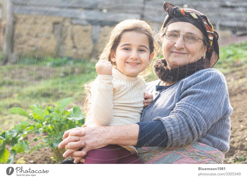 Porträt eines glücklichen kleinen Mädchens mit seiner älteren Großmutter im Garten Lifestyle Stil Spielen Muttertag Kind Mensch Frau Erwachsene