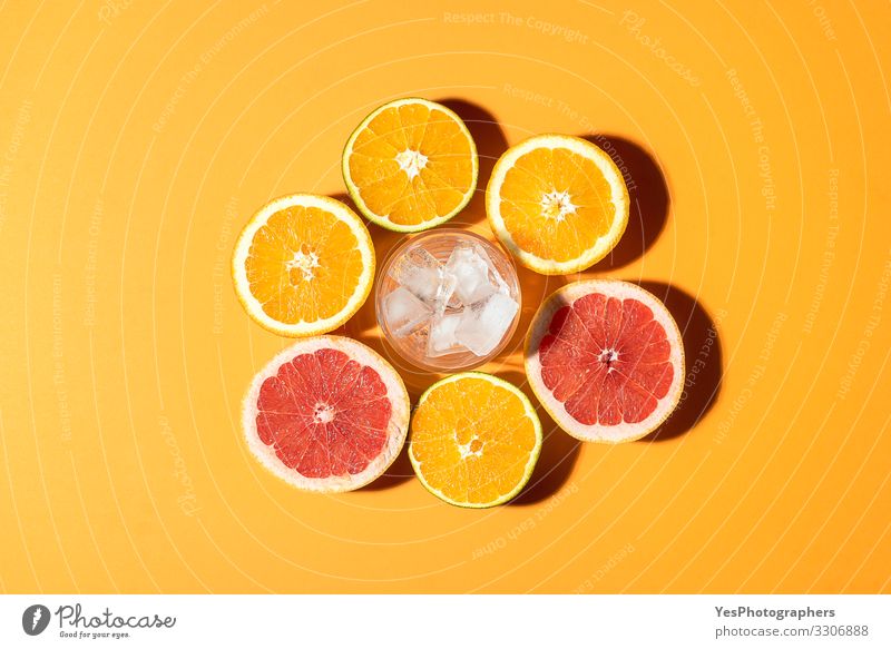 Zitrusfrüchte und Glas mit Eis im Sonnenlicht. Frucht Orange Frühstück Bioprodukte Vegetarische Ernährung Diät Erfrischungsgetränk Gesunde Ernährung hell rot