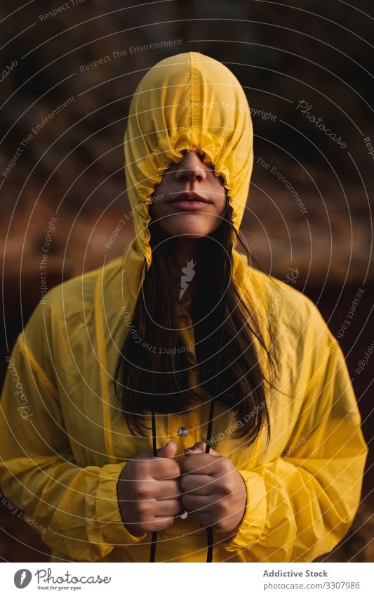 Junge Dame im gelben Regenmantel spaziert in der Natur Frau Deckblatt reisen brünett Tourismus Abenteuer Wald Kapuze Urlaub Erholung Wetter wasserdicht