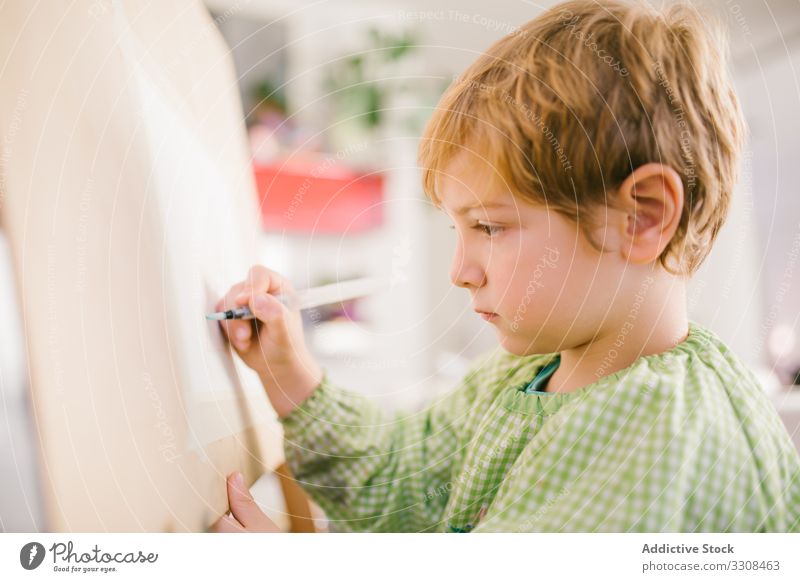 Kind zeichnet zu Hause auf Leinwand zeichnen Bild Junge Kunst ernst Windstille Farbe Hobby heimwärts friedlich lässig Kindheit Appartement flach kreativ