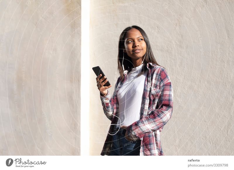 Porträt einer afroamerikanischen jungen Frau, die auf der Straße steht und ein Mobiltelefon benutzt Lifestyle Glück schön Telefon PDA Technik & Technologie