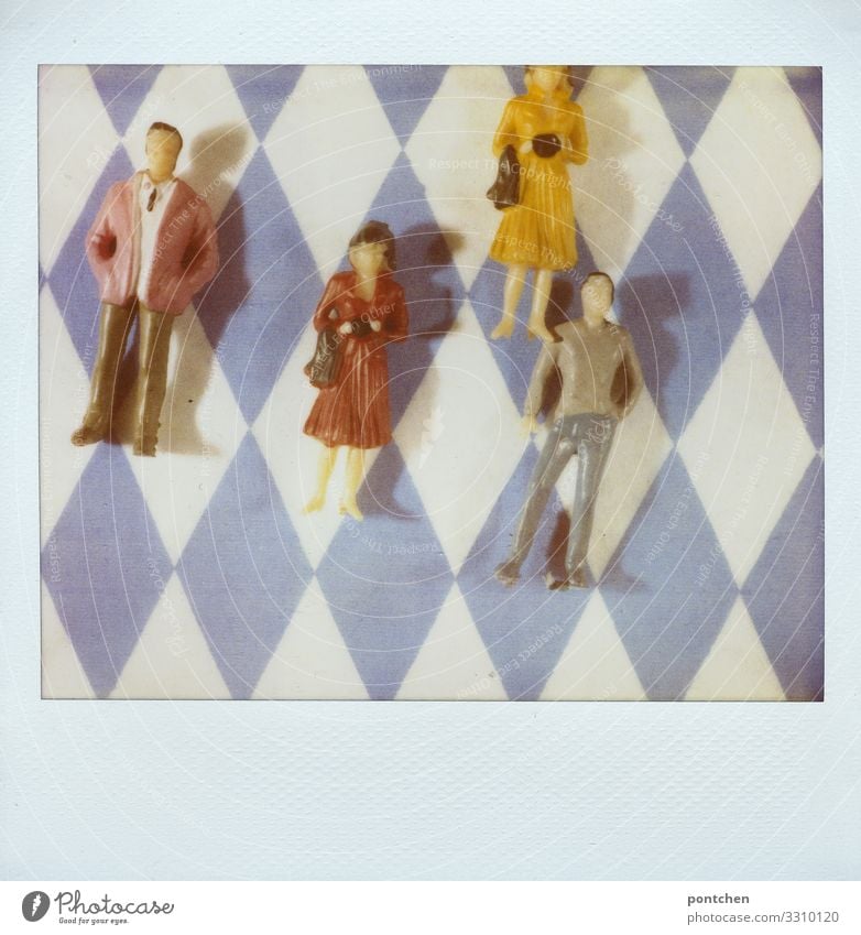 Polaroid zeigt Spielzeug Menschen  weiblich und männlich liegend auf bayrischem Rautenmuster maskulin feminin Frau Erwachsene Mann Paar Partner 4 Menschengruppe