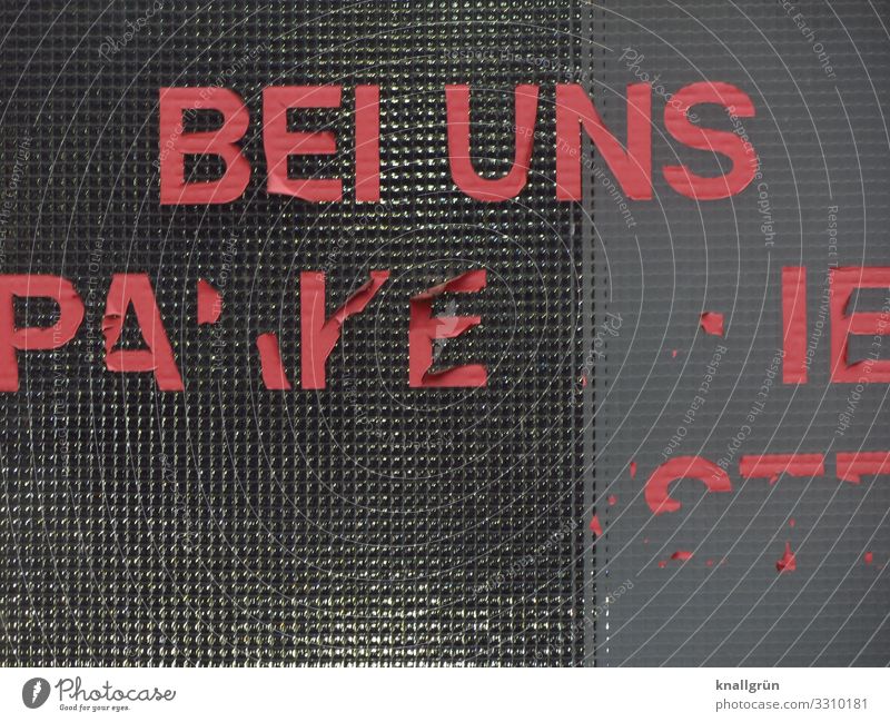 BEI UNS Parkhaus Fenster Glasscheibe Klebebuchstaben Etikett Schriftzeichen Kommunizieren kaputt Stadt grau rot Farbfoto Außenaufnahme Menschenleer