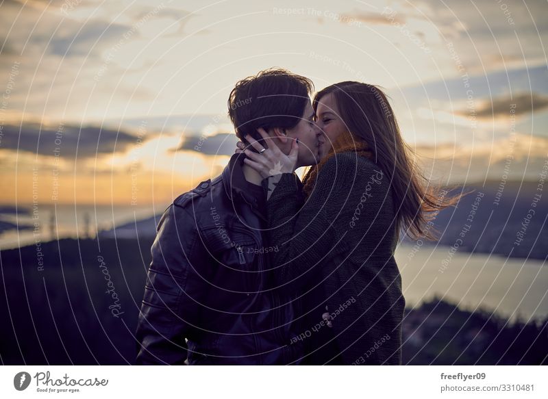 Junges Paar, das sich im Freien küsst. Lifestyle Freude Sonne Flirten Mensch Frau Erwachsene Mann Freundschaft Jugendliche Natur Herbst Park Hut Küssen Lächeln