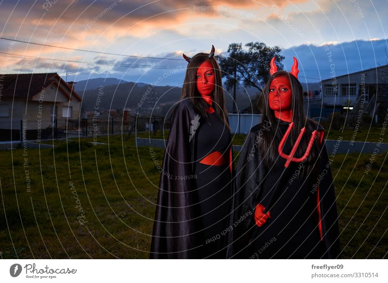 Zwei junge Frauen in einem Teufelskostüm an Halloween in Spanien elegant schön Spielen Erwachsene Mode Bekleidung Kleid Anzug Stiefel dünn Erotik lang niedlich