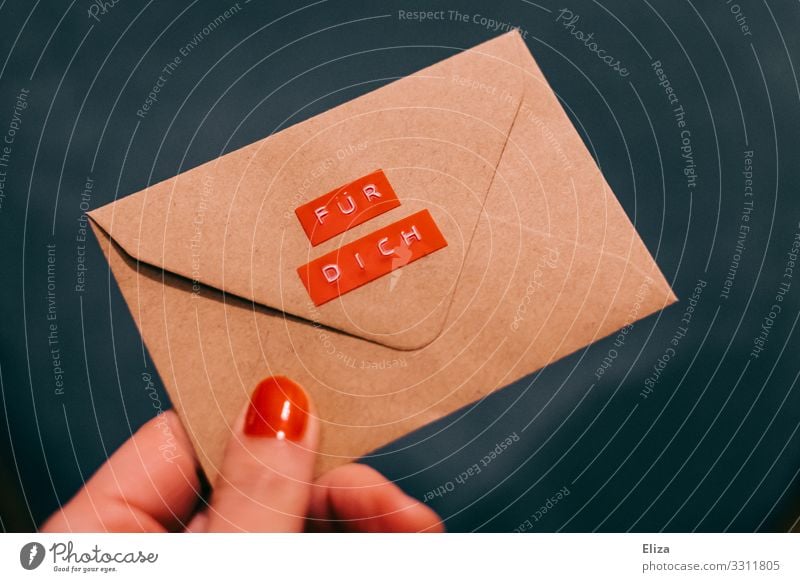 Eine Hand mit rotem Nagellacke übergibt einen Briefumschlag auf dem "Für Dich" steht blau geben schenken für dich Etikett Post Information Valentinstag