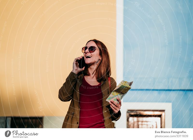junge Frau beim Lesen einer Karte auf gelbem und grünem Hintergrund. reisekonzept Großstadt Landkarte mehrfarbig Hintergrundbild Ferien & Urlaub & Reisen