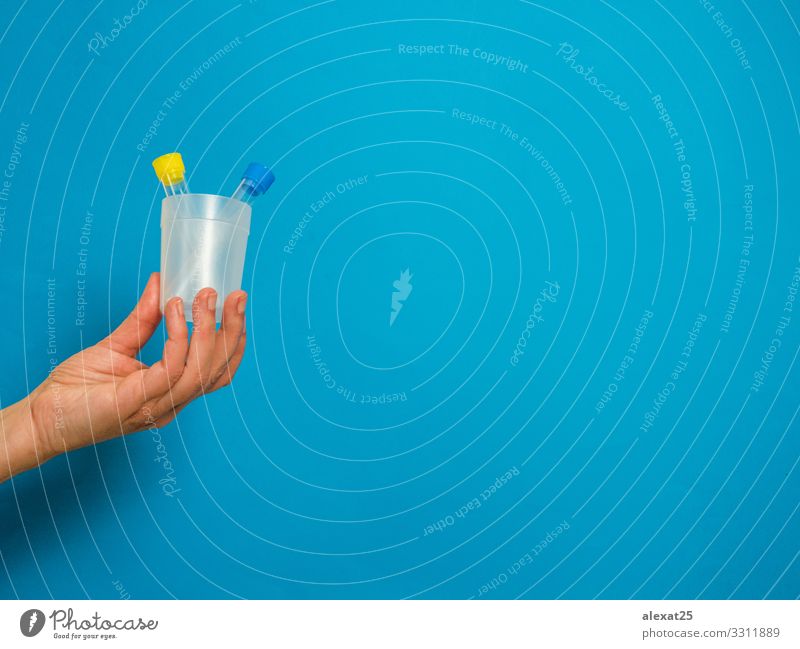 Hand mit Analyseröhrchen auf blauem Hintergrund mit Kopierfeld Flasche Gesundheitswesen Krankheit Medikament Wissenschaften Labor Prüfung & Examen Container