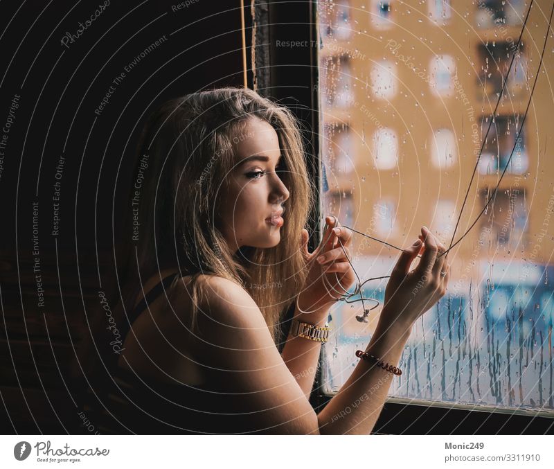 Schöne blonde Frau, die den Regen durch das Fenster beobachtet Lifestyle schön Haare & Frisuren Winter Erwachsene Jugendliche Mode Anzug Jacke Tropfen