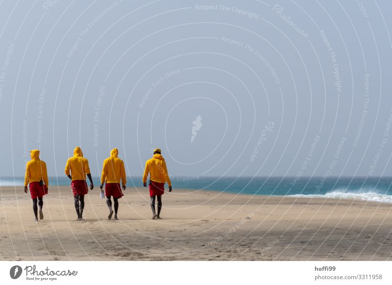 vier Rettungsschwimmer in gelben Hoodies und roten Hosen am Strand Ferien & Urlaub & Reisen Tourismus Ferne Sommer Sonne Mensch Freundschaft 4 18-30 Jahre