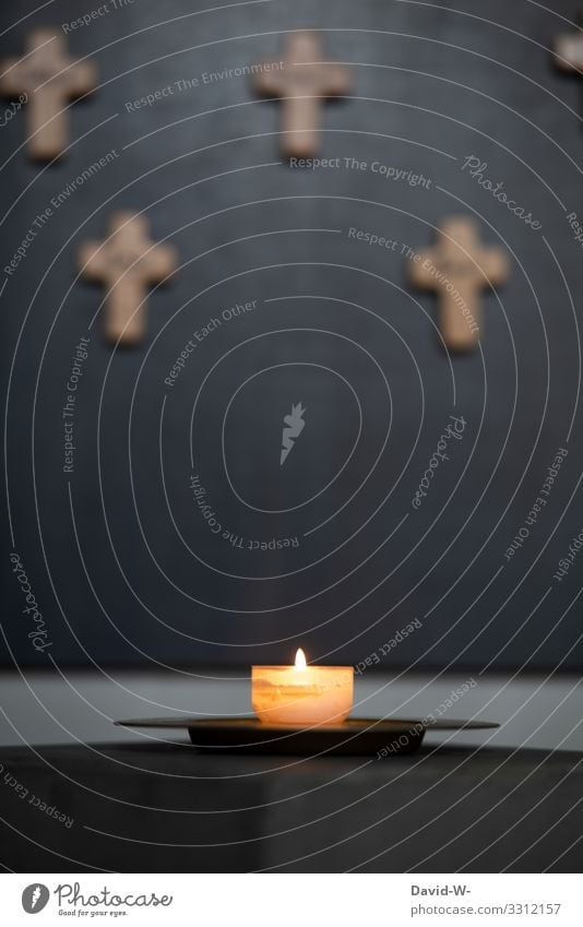 eine brennende Kerze mit Kreuzen im Hintergrund beten betend Kirche Glaube & Religion Hoffnung Trauer glauben trauern Gebet Kirchentag Religion & Glaube Gott