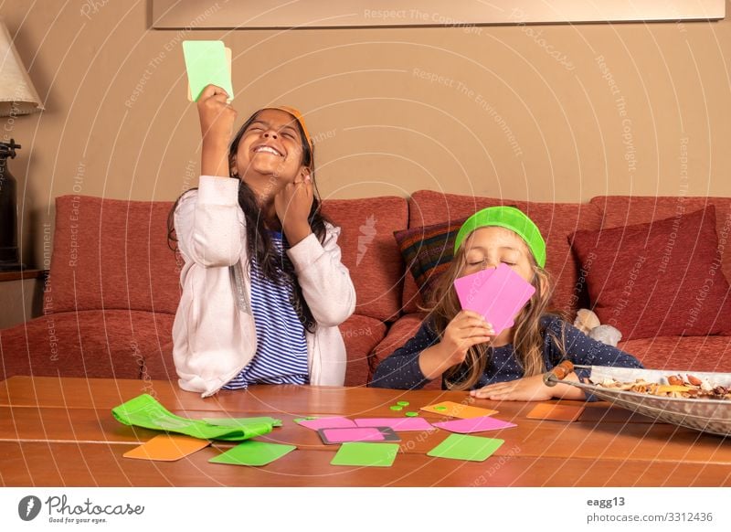Mädchen feiert nach dem Gewinn ihres Kartenspiels Lifestyle Freude Freizeit & Hobby Spielen Haus Sofa Wohnzimmer Entertainment Erfolg Kind sprechen Mensch