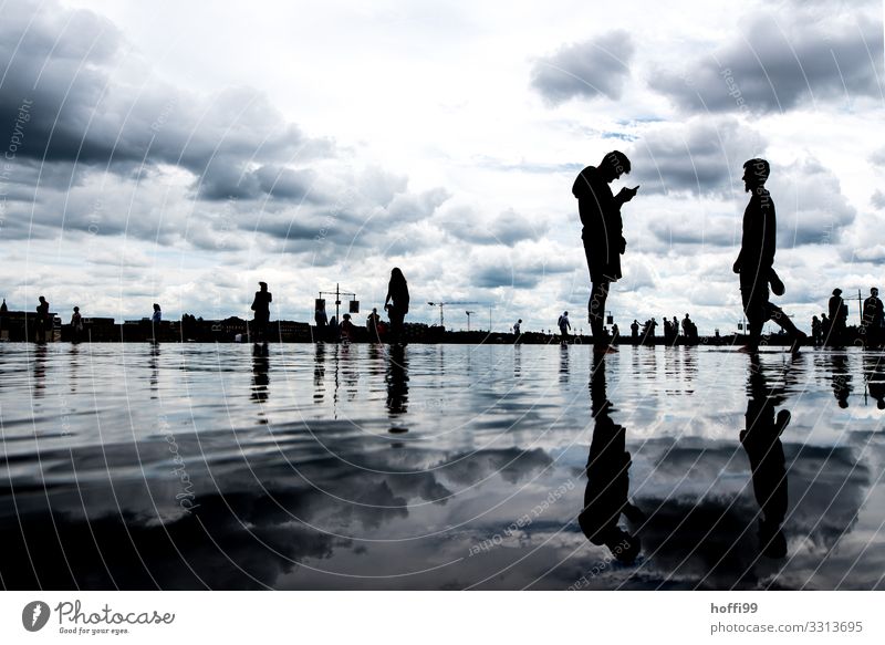 Silhouette von sich spiegelten Menschen auf einer Wasserfläche Handy 2 18-30 Jahre Jugendliche Erwachsene Himmel Wolken Klima schlechtes Wetter Bewegung