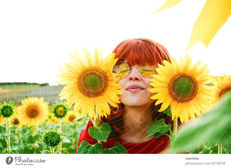 Reizende rothaarige Frau genießt den Tag auf einem Sonnenblumenfeld Rotschopf Fröhlichkeit Frühling jung genießen Freiheit Leben Blumen Sommer Feiertage Spaß