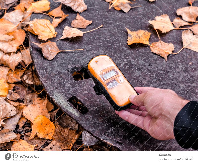 Dosimetergerät in der Nähe eines radioaktiven Objekts in Tschernobyl in der Hand Ferien & Urlaub & Reisen Tourismus Ausflug Mann Erwachsene Natur Herbst Blatt