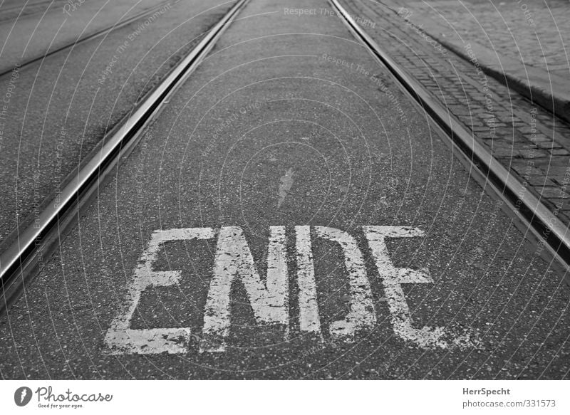 This is the ENDE Stadt Schriftzeichen trist schwarz weiß Ende Schienenverkehr Gleise Straßenbahn Beschriftung Verkehrsschild Buchstaben Straßenbelag