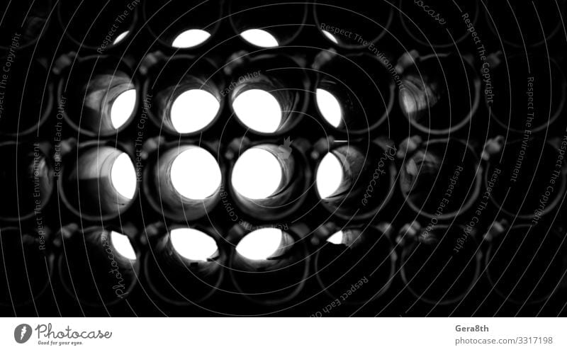abstrakter dunkler Hintergrund von Rundrohren Metall dunkel trist kreisen Geometrie Golfloch industriell bügeln Licht Monochrom Röhren Wiederholung technisch