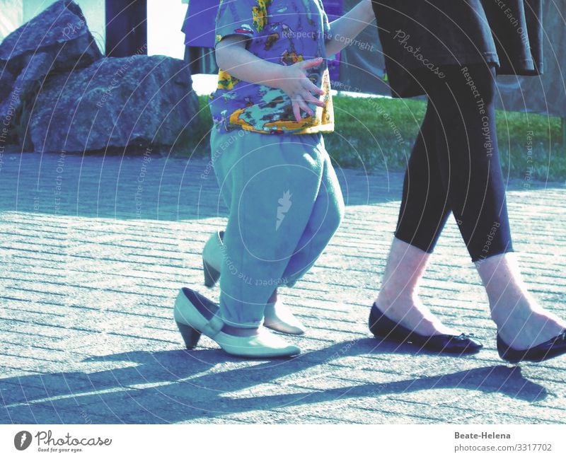 Füße von Frau und Kind, das zu große Schuhe trägt Erwachsene Beine Asphalt Straße Damenschuhe Außenaufnahme mehrfarbig zu großer Fuß Weg gepflastert skurril