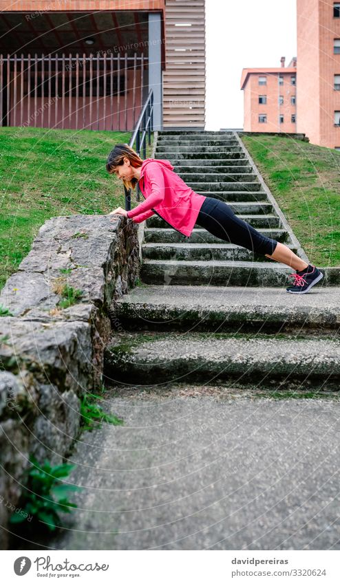 Sportlerin macht Liegestütze im Freien Glück Körper Mensch Frau Erwachsene Gras Turnschuh Fitness dünn natürlich unterstützt Wand Treppe urban Training üben