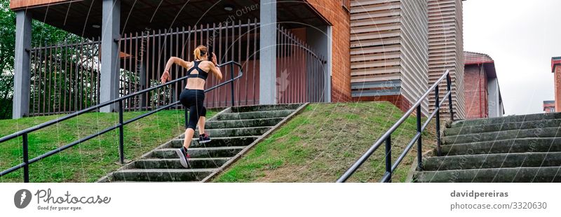 Sportlerin, die im Freien eine Treppe hinaufsteigt Klettern Bergsteigen Joggen Internet Mensch Frau Erwachsene Turnschuh Fitness dünn Athlet rennen treppauf