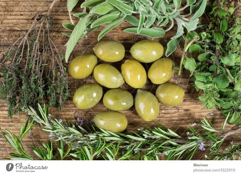 Grüne Oliven mit verschiedenen Kräutern auf einem Holztisch. Essen Vegetarische Ernährung Diät Natur Pflanze Baum Blatt frisch natürlich grün oliv Erdöl