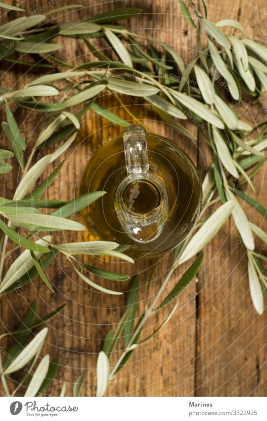 Glas Glas und Blätter aus nativem Olivenöl auf Holztisch. Essen Vegetarische Ernährung Diät Flasche Natur Pflanze Baum Blatt frisch natürlich grün oliv Erdöl