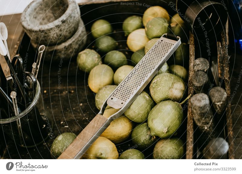 Limetten in einem Industriekorb mit Reibe Lebensmittel Gemüse Frucht Geschirr Schalen & Schüsseln Lifestyle Gesundheit füttern genießen Häusliches Leben
