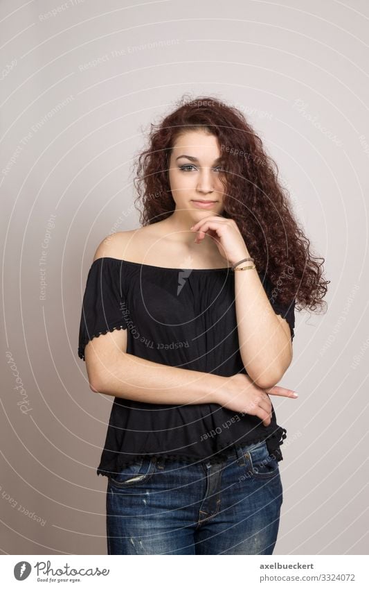 nachdenkliche junge Frau mit langem lockigem Haar Mensch feminin Junge Frau Jugendliche Erwachsene 1 13-18 Jahre 18-30 Jahre Jeanshose Bluse brünett langhaarig