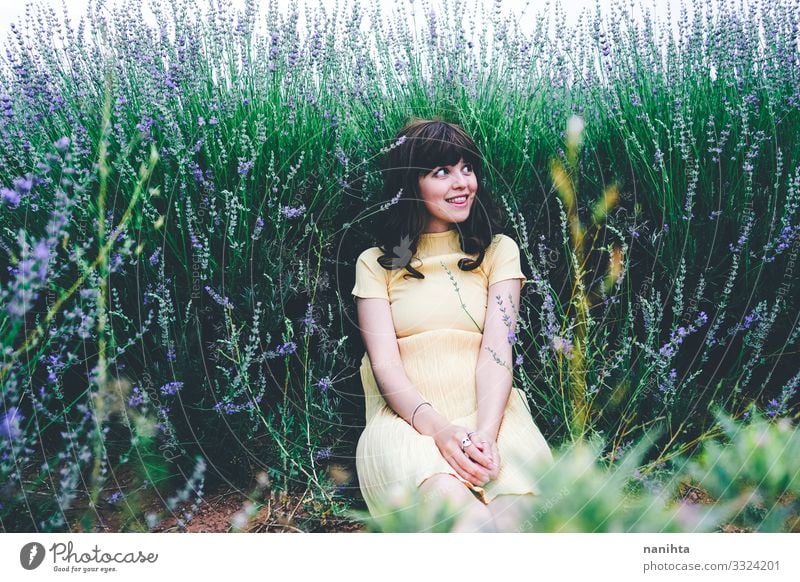 Junge brünette Frau sitzt umgeben von Lavendel jung hübsch retro altehrwürdig Natur natürlich wirklich offen sich[Akk] entspannen Ruhe Szene Blumen Frühling