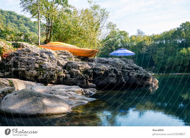 orangefarbenes Boot und blauer Regenschirm am Fluss im Wald Ferien & Urlaub & Reisen Tourismus Camping Berge u. Gebirge wandern Natur Landschaft Pflanze Himmel