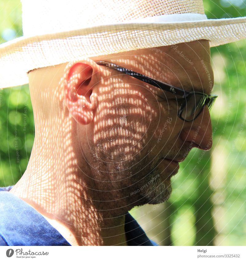 Gesicht eines Mannes im Profil mit Sonnenhut und Schattenmuster im Gesicht Mensch maskulin Männlicher Senior Erwachsene Kopf Ohr 1 45-60 Jahre Brille Hut stehen