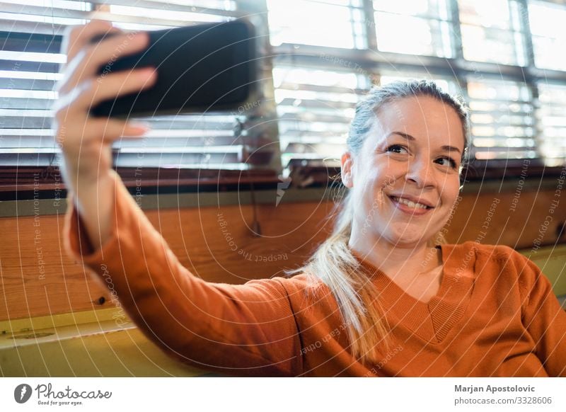 Junge Frau, die einen Selfie im Haus am Fenster macht Lifestyle Freude Handy Fotokamera Technik & Technologie Telekommunikation Internet feminin Jugendliche