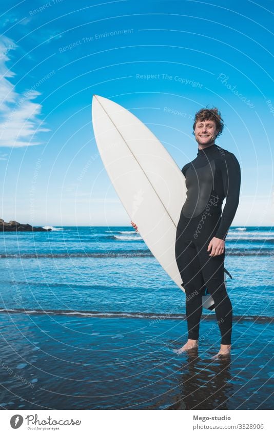 Surfer, der mit seinem Surfbrett im Meer steht. Lifestyle Freude Glück Erholung Freizeit & Hobby Abenteuer Strand Wellen Sport Wassersport Mensch maskulin Mann