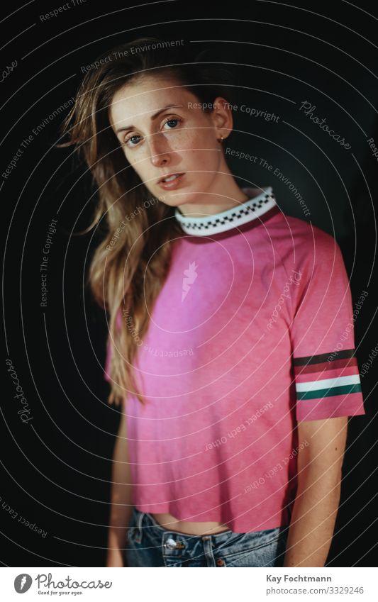 junge Frau in rosa Hemd 20s 30s Erwachsener schöne Frau schwarzer Hintergrund blond braune Haare Freizeitkleidung Kaukasier betroffen Selbstvertrauen Vielfalt