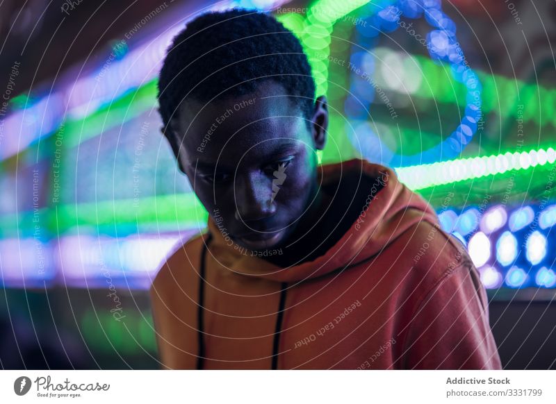 Afroamerikanischer Typ auf Jahrmarkt Mann Messegelände Nacht farbenfroh Illumination ethnisch modern stylisch ruhen Wochenende männlich festlich Veranstaltung