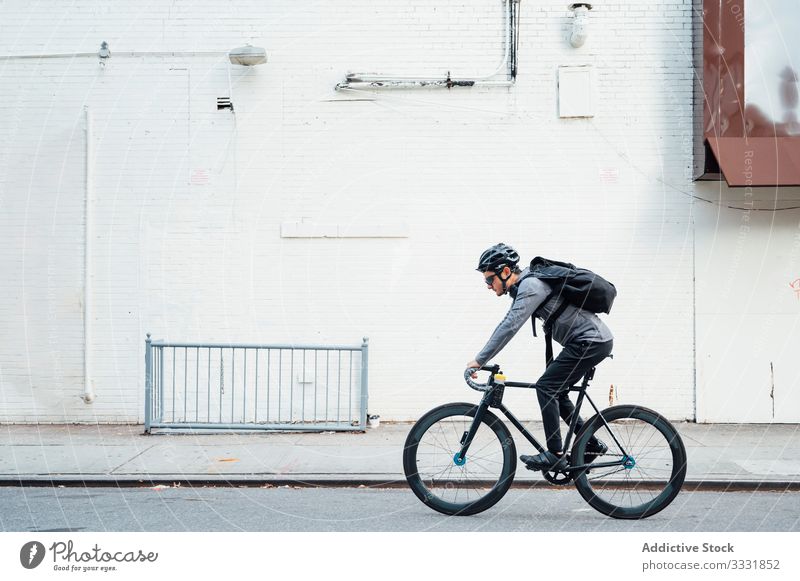 Profi-Radsportler mit Smartphone Mann Radfahrer Fahrrad Großstadt Straße Asphalt Gerät Brille männlich Schutzhelm Sport Lifestyle Bewegung urban Messenger