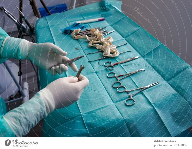 Anonymer Arzt, der während der Operation im Krankenhaus über chirurgische Instrumente spricht Werkzeug Gerät Uniform Handschuhe steril vorbereitend Chirurgie