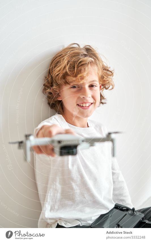 Kind manipuliert eine Drohne und die ihm gerade gegebene Fernbedienung Fotokamera Dreharbeit Hobby Roboter Bewegung Antenne Technik & Technologie Fotografie