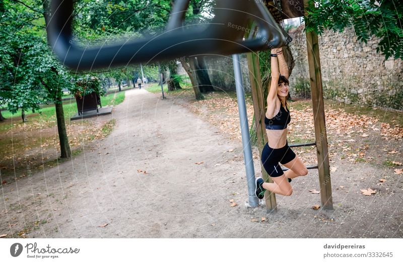 Frau macht Affenübungen auf Ringen Lifestyle Körper Sport Mensch Erwachsene Baum Park Wege & Pfade Turnschuh Fitness Lächeln dünn stark Tatkraft anstrengen