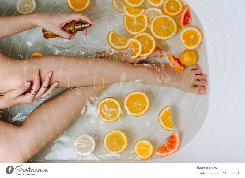 Hand und Beine der Frau in einer mit Wasser gefüllten Badewanne aromatisch Schwimmen & Baden Beautyfotografie Bombe Blase Schaumblase Pflege Zitrone