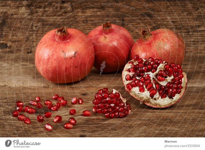 reife Granatapfelfrüchte auf Holztisch. Frucht Dessert Vegetarische Ernährung Diät Saft Garten Tisch frisch natürlich saftig rot Farbe Gesundheit Vitamin