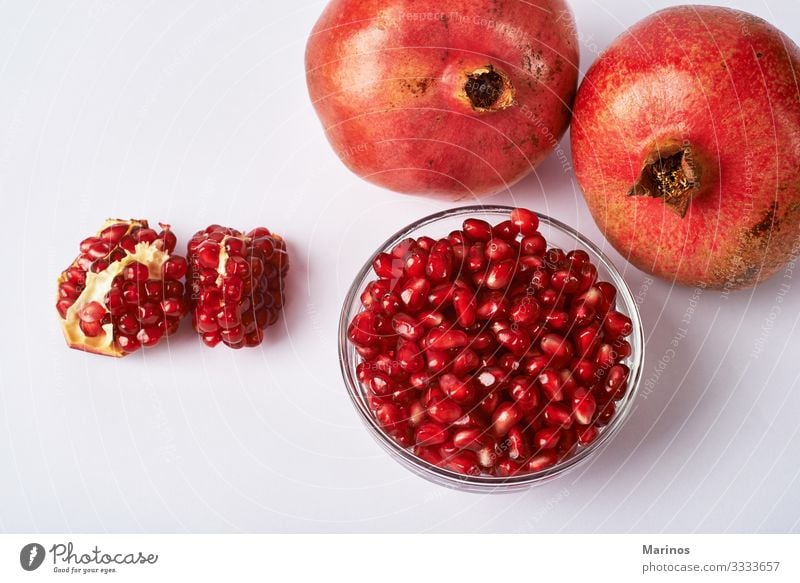 Granatapfelfrüchte und -kerne auf weißem Hintergrund. Frucht Dessert Vegetarische Ernährung Diät Saft Garten frisch natürlich saftig rot Farbe Gesundheit